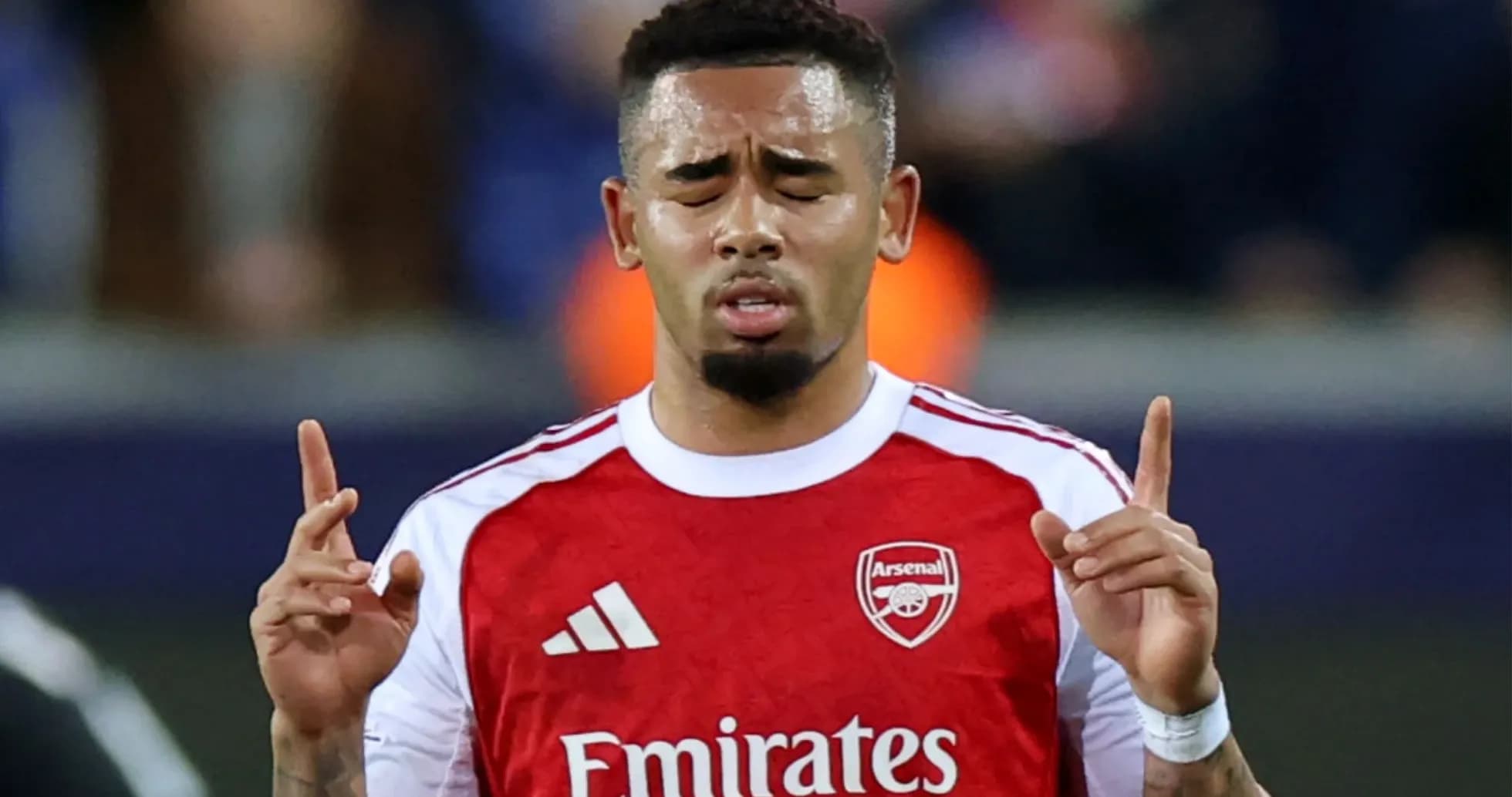 Jugador de Arsenal levantando las manos en el campo