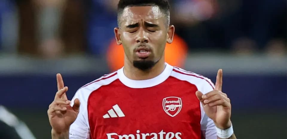 Jugador de Arsenal levantando las manos en el campo