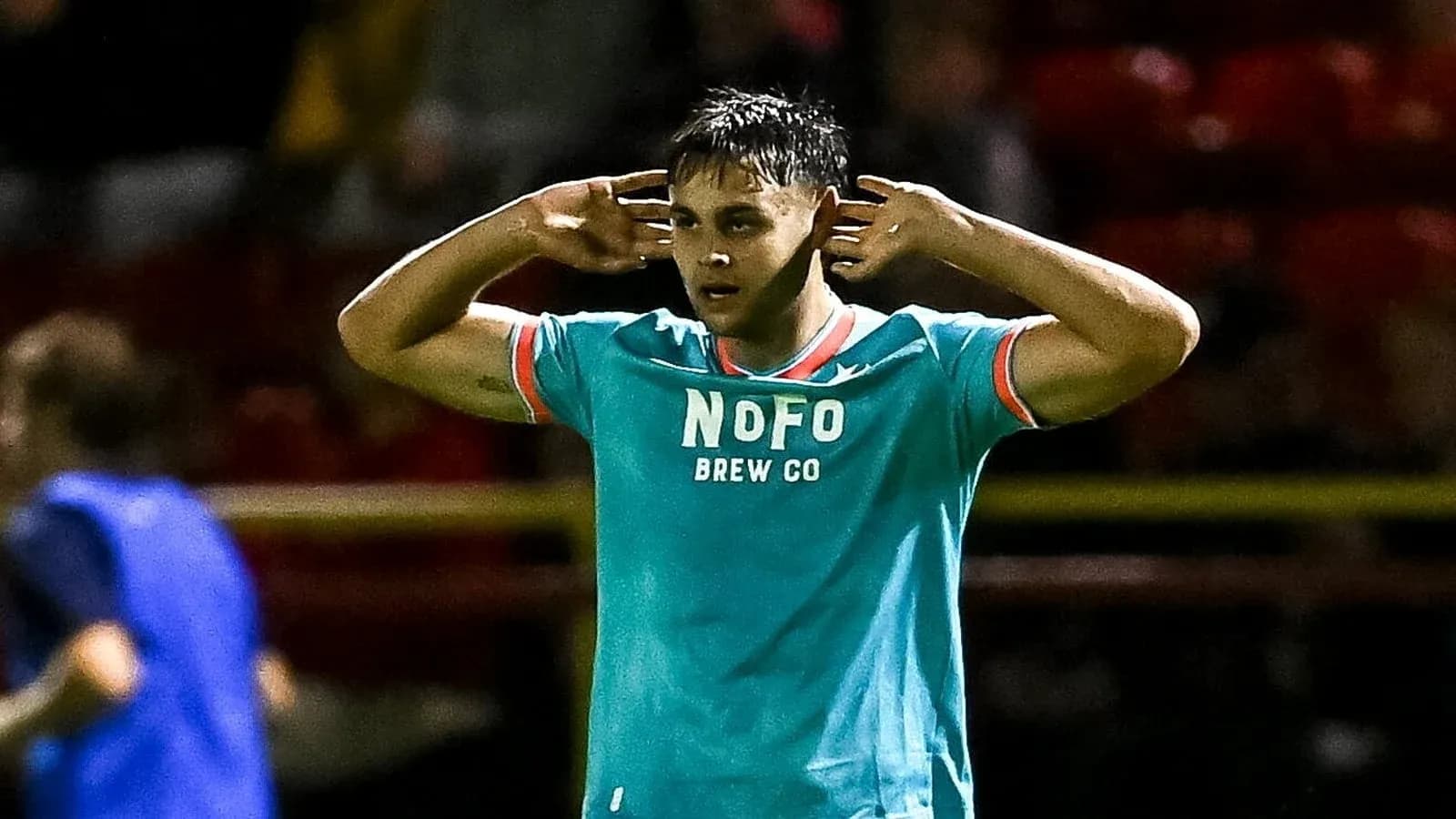 Jugador con camiseta NOFO celebrando en el campo