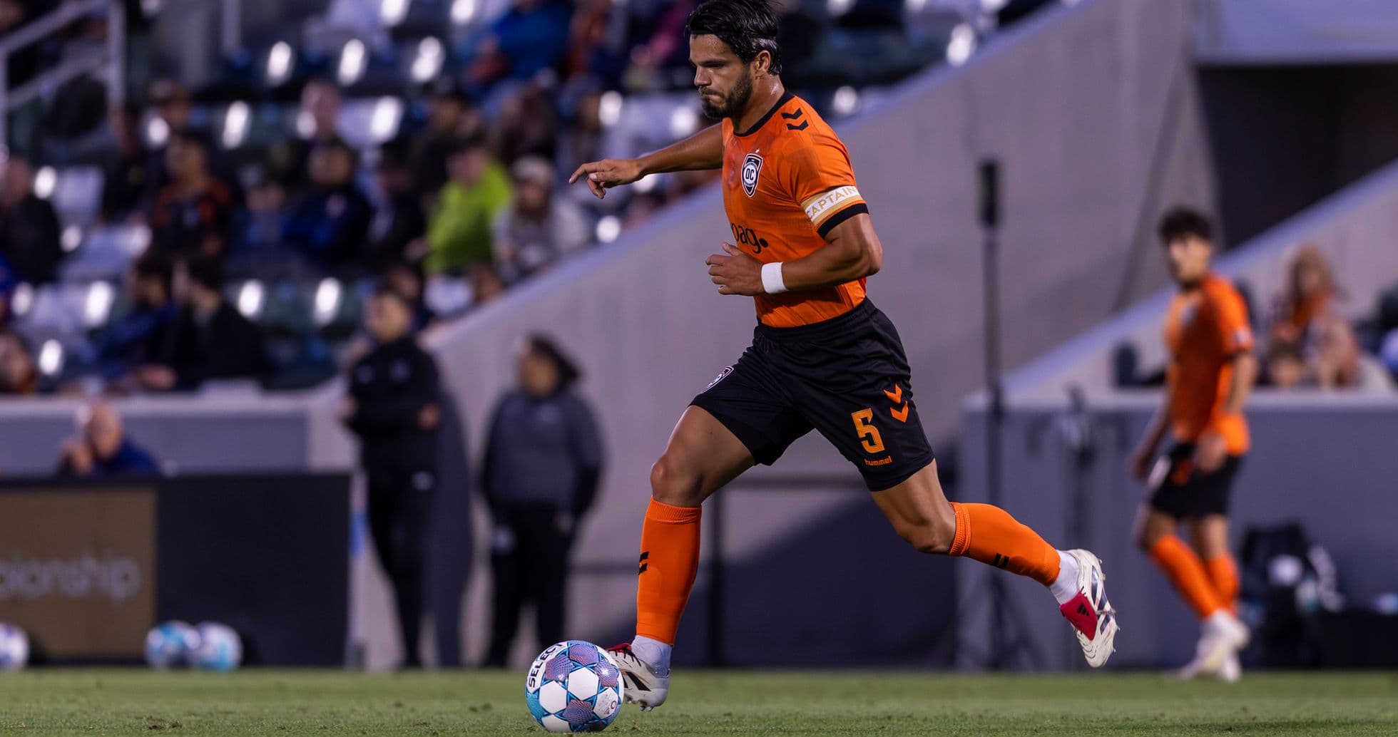 Jugador corriendo con el balón en el partido