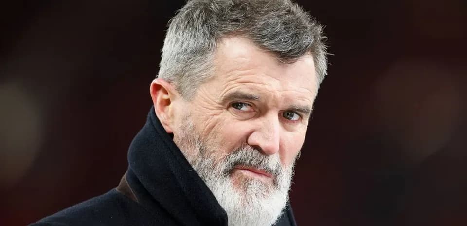 Hombre con barba y abrigo mirando hacia la cámara