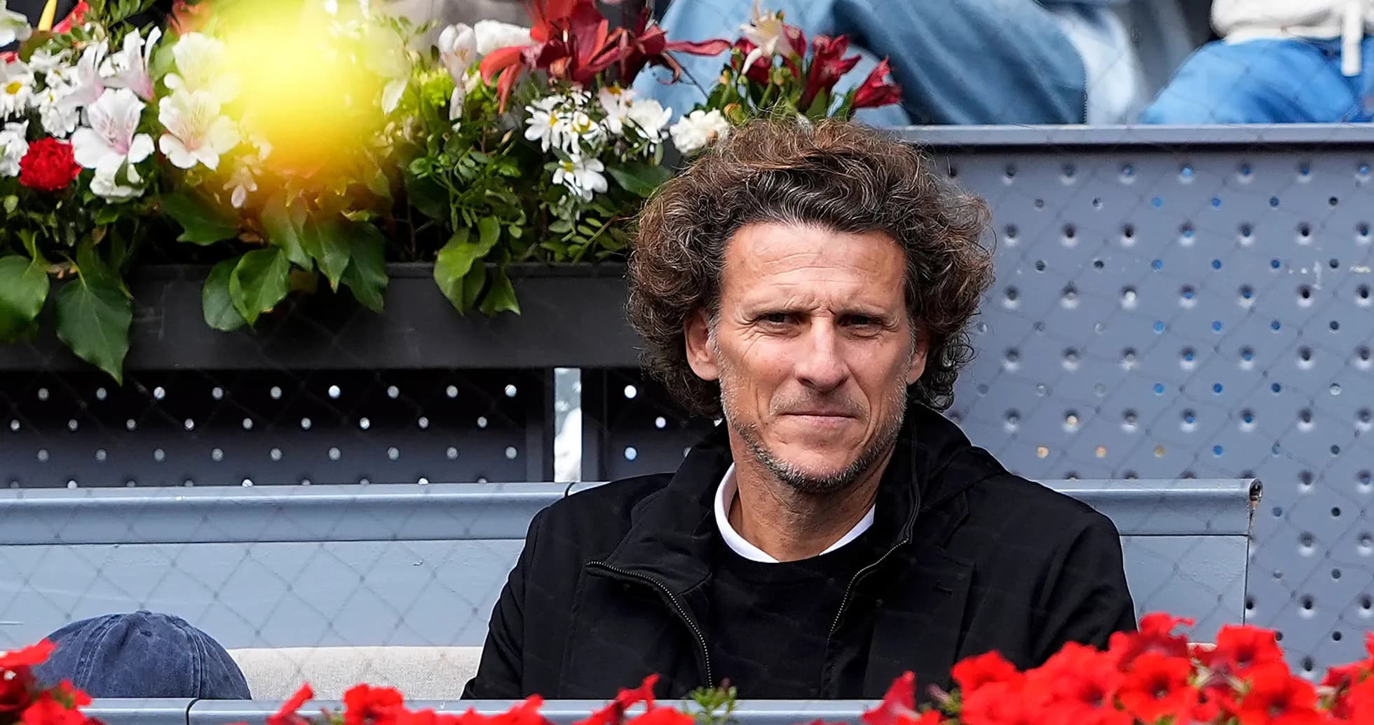 Hombre sentado entre flores en un evento deportivo