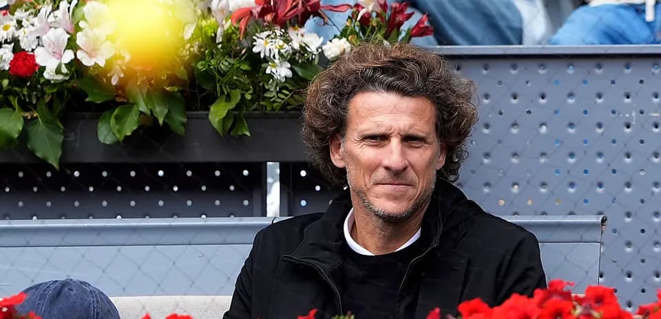 Hombre sentado entre flores en un evento deportivo