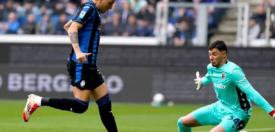 Jugador de Atalanta ante el portero de Bologna