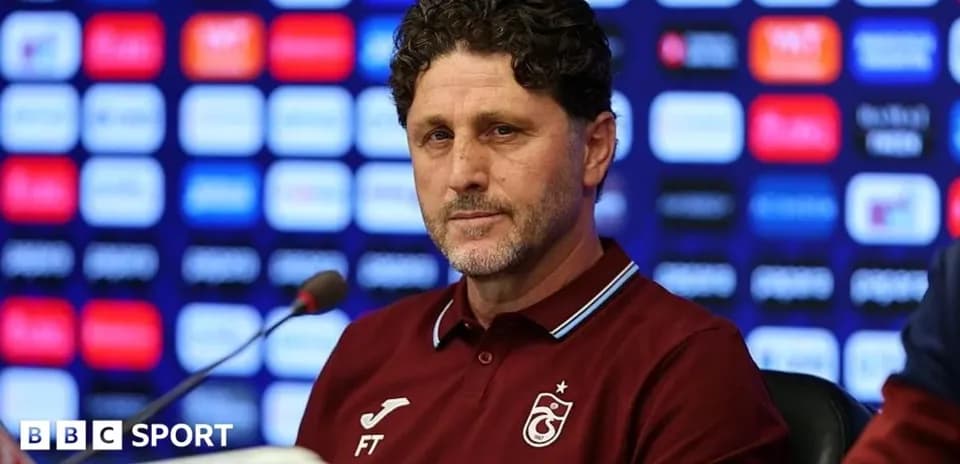 Entrenador en rueda de prensa con fondo de logos