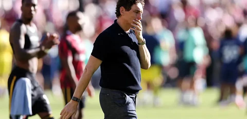 Entrenador caminando en el campo tras el partido