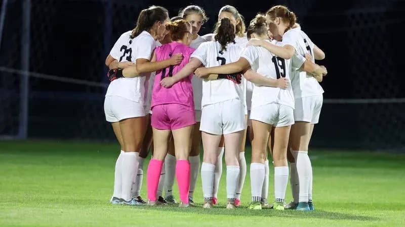 Equipo femenino de fútbol en círculo antes del partido