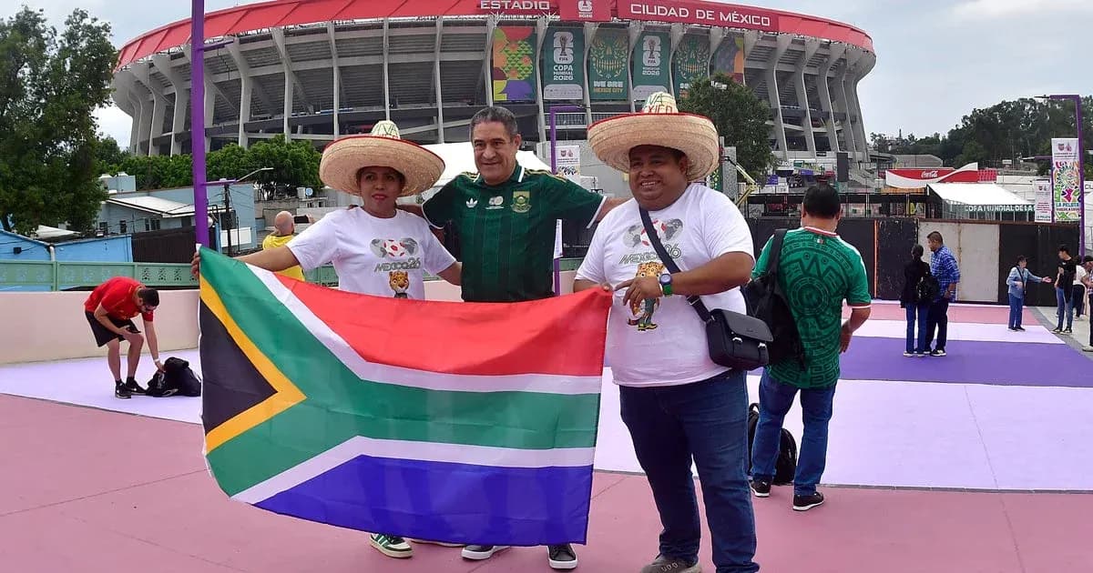 Aficionados sosteniendo bandera de Sudáfrica en estadio