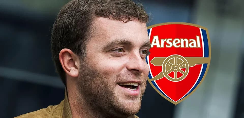 Hombre sonriendo con logo de Arsenal de fondo