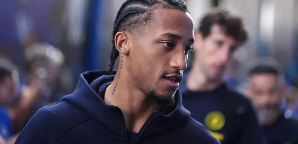 Jugador caminando con sudadera antes del partido