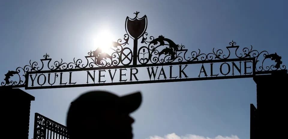 Reja con el lema 'YOU'LL NEVER WALK ALONE' iluminada por el sol