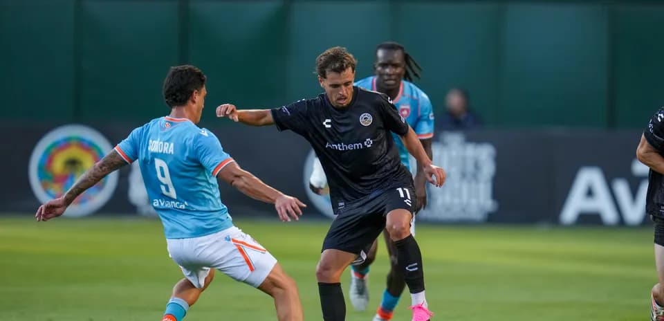 Jugador driblando en el partido de fútbol