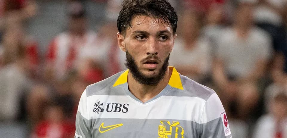 Jugador de fútbol con camiseta gris y amarilla