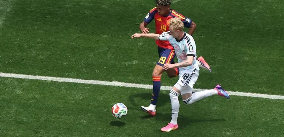 Jugador de Alemania desafiando a rival español en campo