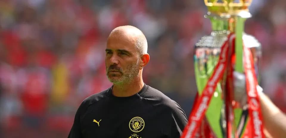 Entrenador de Manchester City observando trofeo en campo