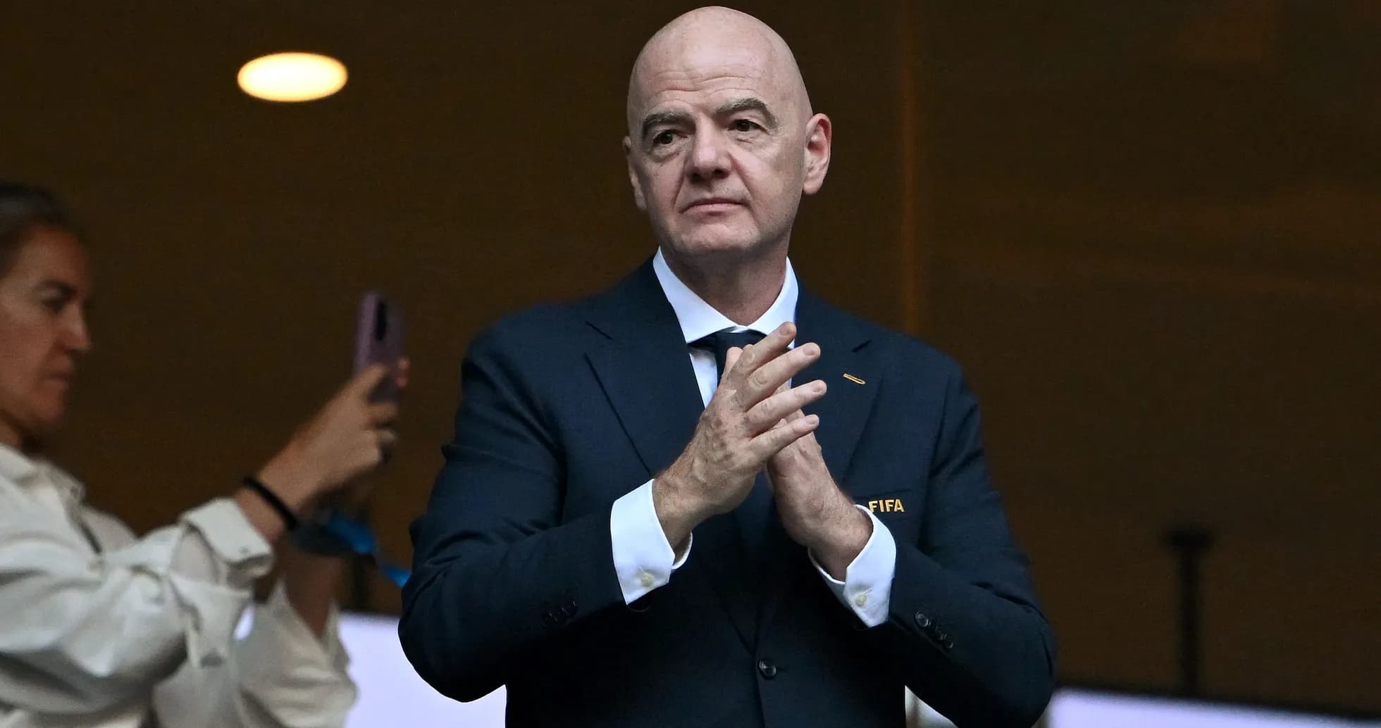 Hombre aplaudiendo en evento con logo de FIFA