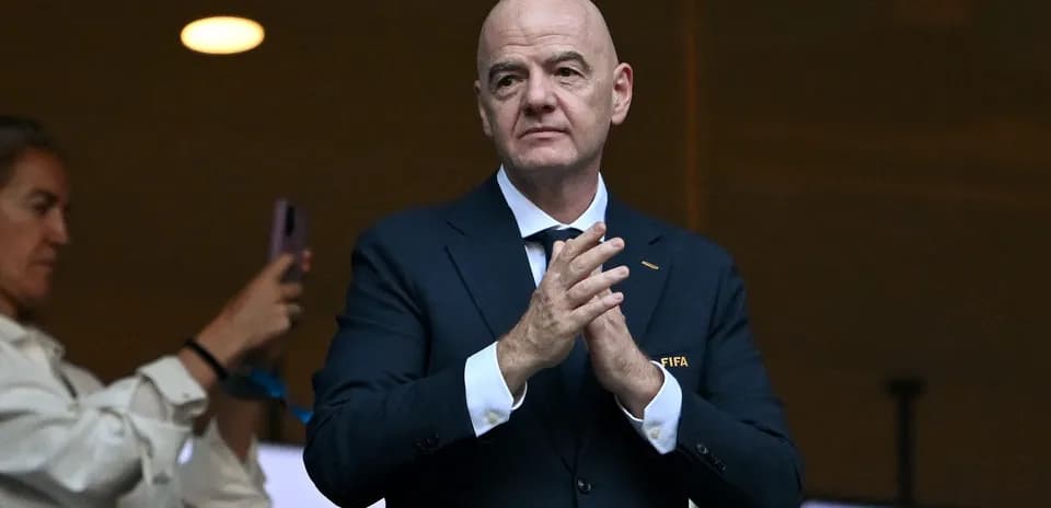 Hombre aplaudiendo en evento con logo de FIFA
