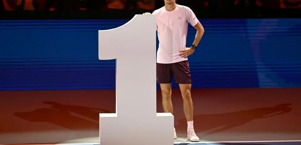 Jugador de tenis junto al número uno en escenario
