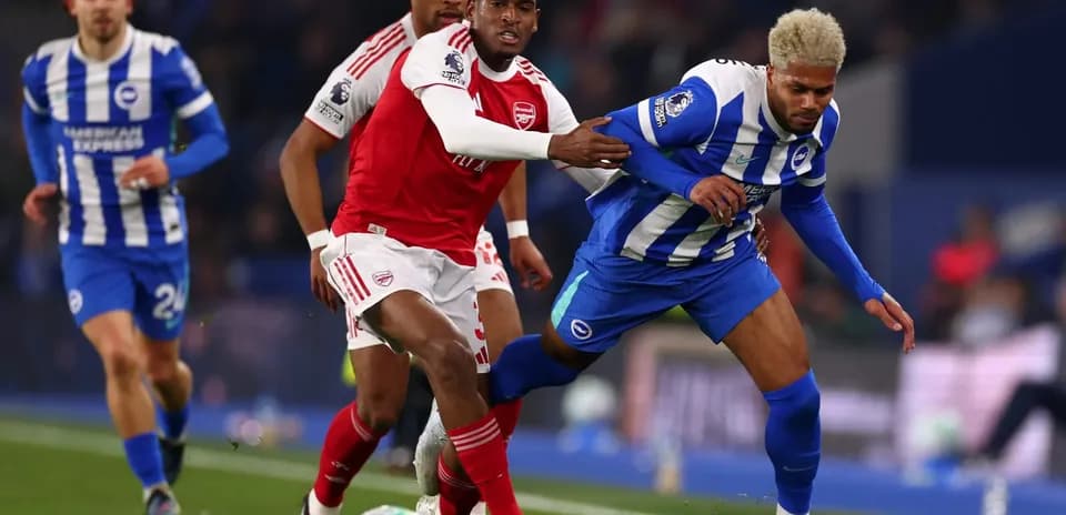 Jugador de Brighton driblando a defensor de Arsenal