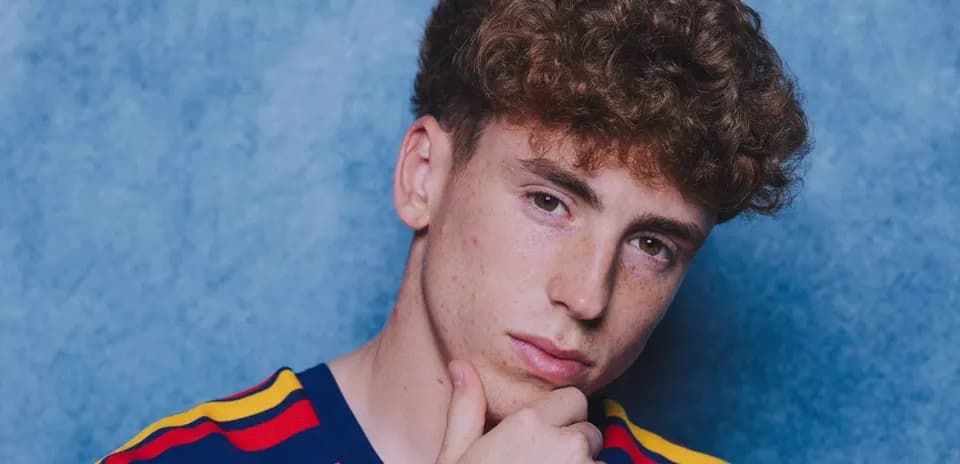 Joven con camiseta a rayas frente a fondo azul