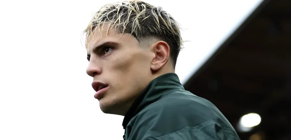 Jugador en perfil con cabello rubio y chaqueta verde
