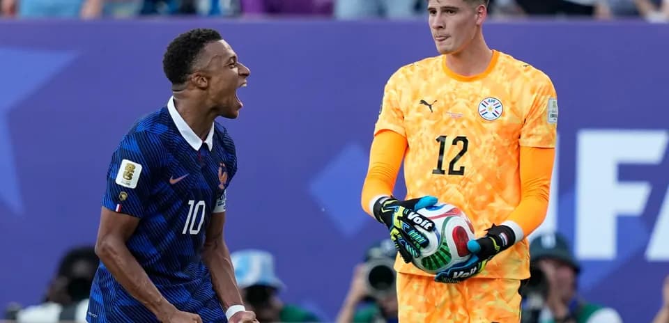 Jugador de Francia celebra mientras el portero paraguayo observa