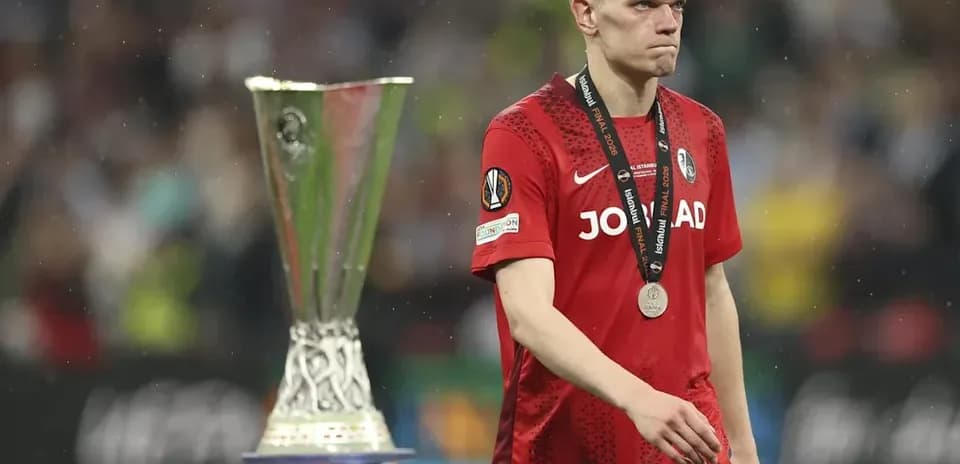 Jugador caminando con medalla junto a trofeo UEFA