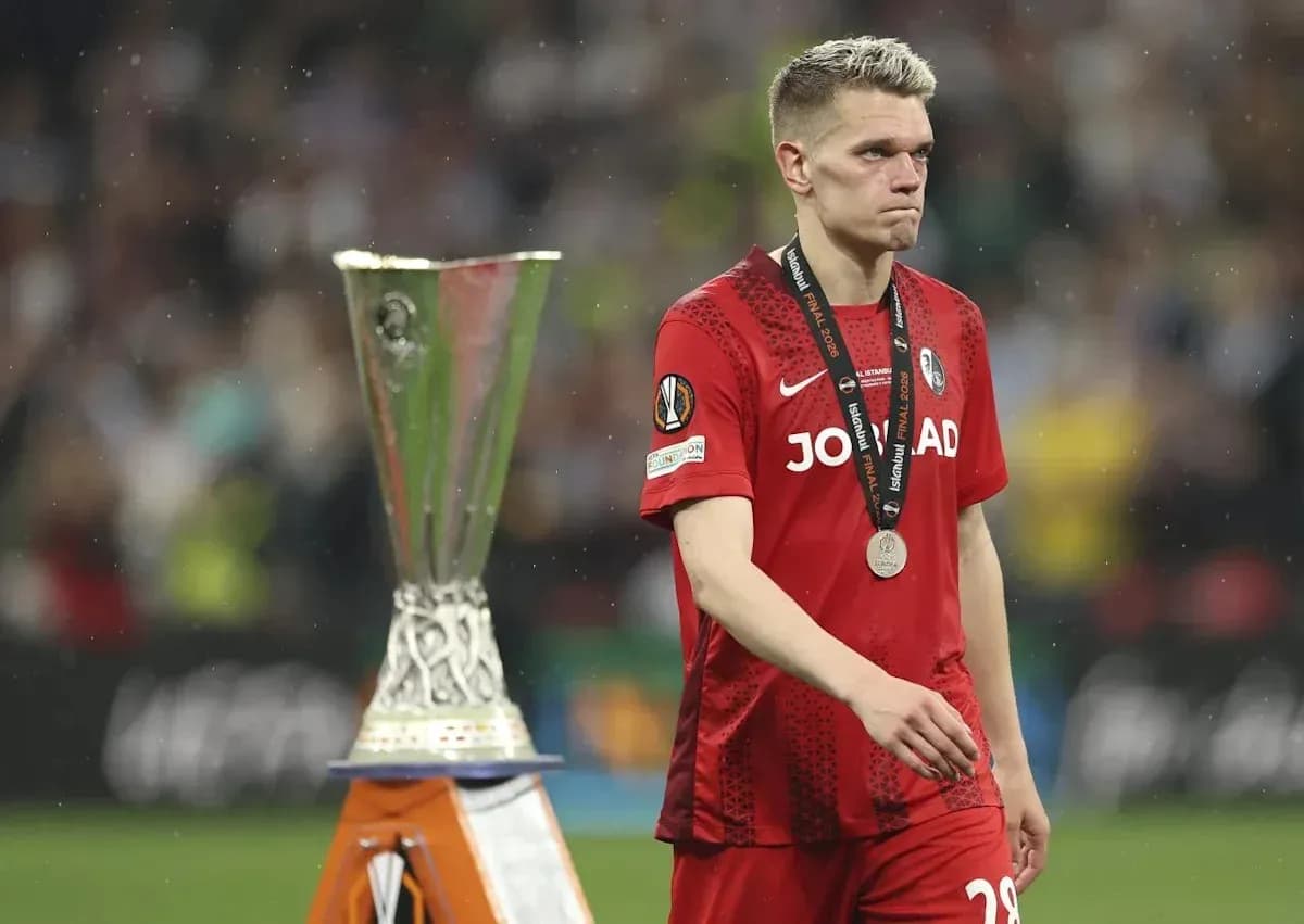 Jugador caminando con medalla junto a trofeo UEFA