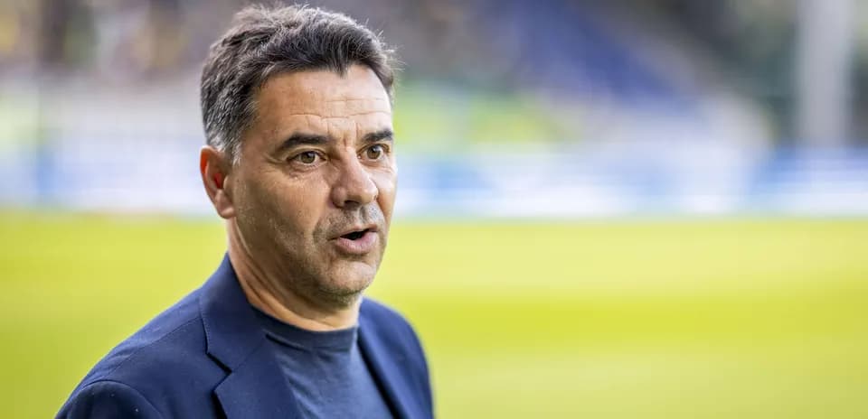 Entrenador hablando en el campo de fútbol