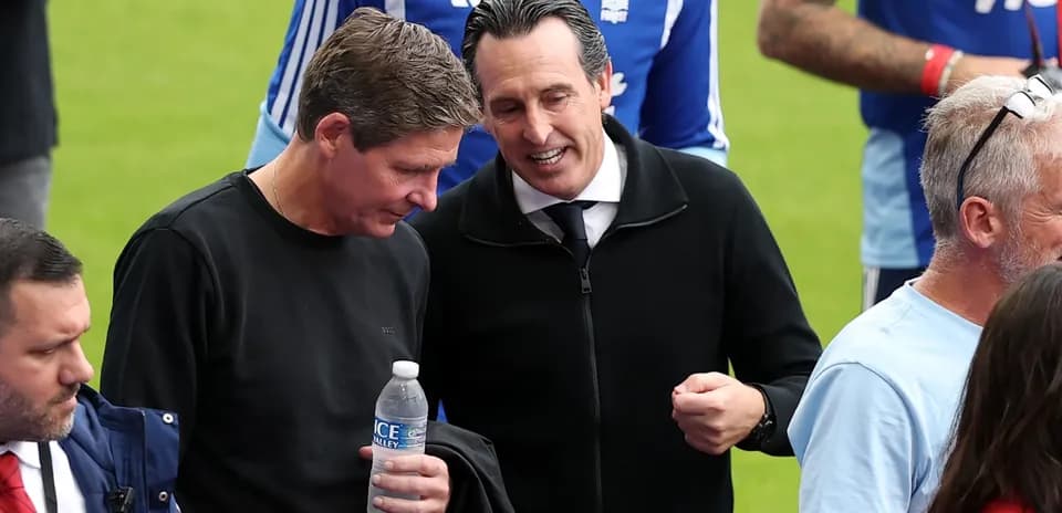 Dos hombres conversando en el campo de fútbol