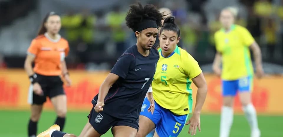 Jugadora de Estados Unidos y Brasil compiten por el balón