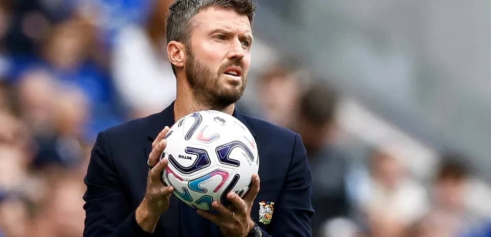 Entrenador sosteniendo un balón durante el partido