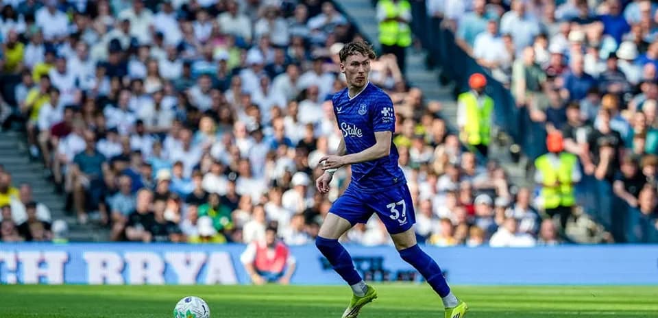 Jugador de fútbol con balón en el campo