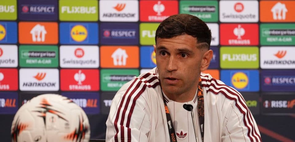 Jugador en conferencia de prensa con balón de fútbol