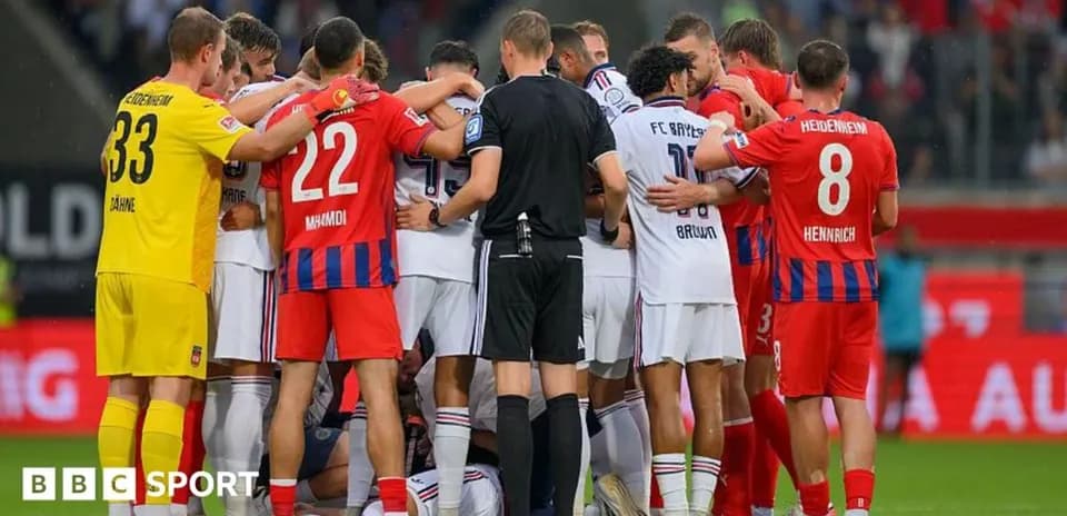 Jugadores rodeando a un compañero caído en el campo
