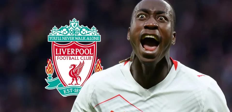Jugador celebrando frente al escudo de Liverpool