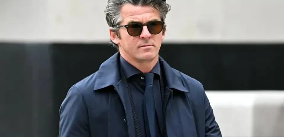 Hombre con gafas de sol y abrigo oscuro caminando