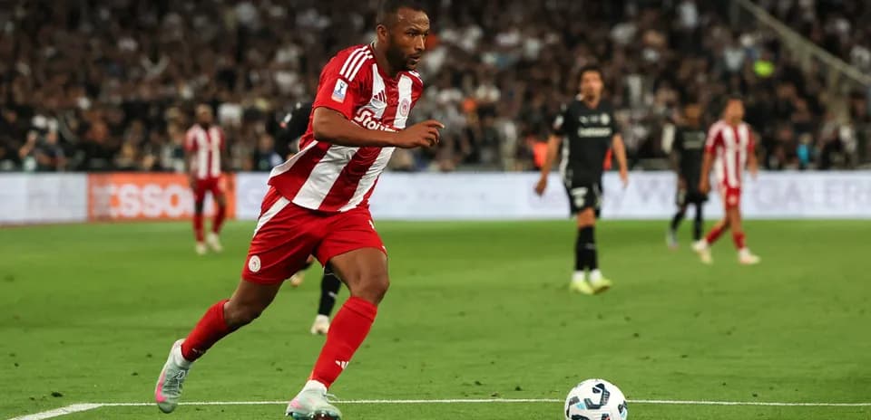 Jugador de Olympiacos corriendo hacia el balón en partido