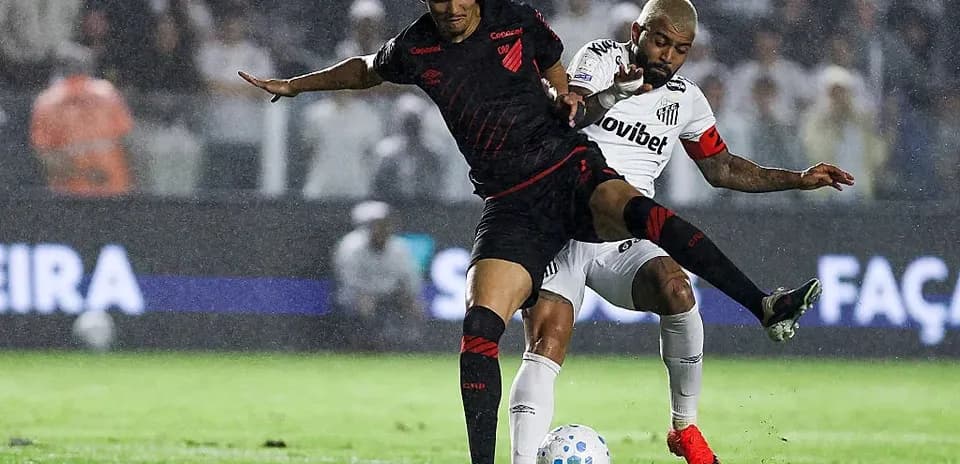 Jugadores compitiendo por el balón en la lluvia