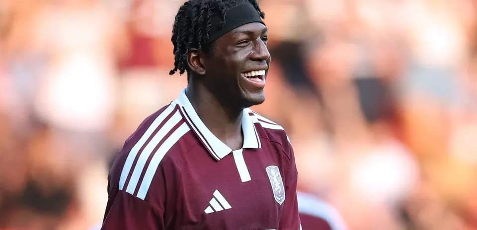 Jugador sonriente con camiseta color burdeos en el campo