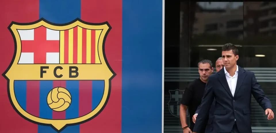 Jugador saliendo del edificio con logo de Barcelona
