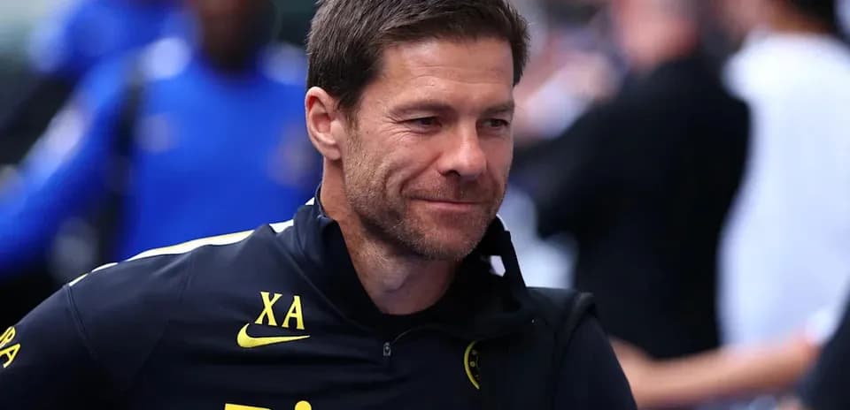 Entrenador sonriendo en el estadio antes del partido