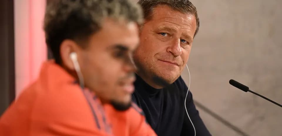 Dos hombres en conferencia de prensa, uno escuchando