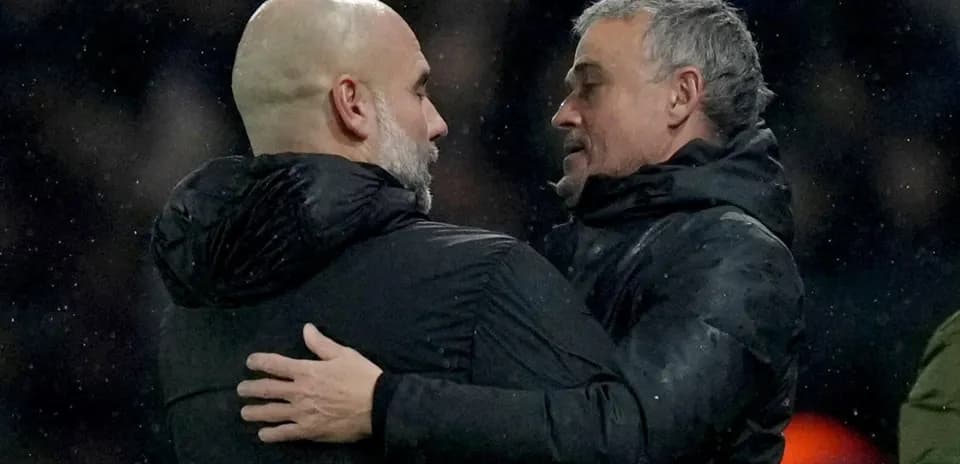 Entrenadores abrazándose tras el partido en lluvia