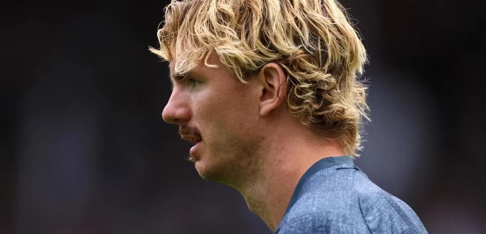 Jugador con cabello rizado en perfil durante partido