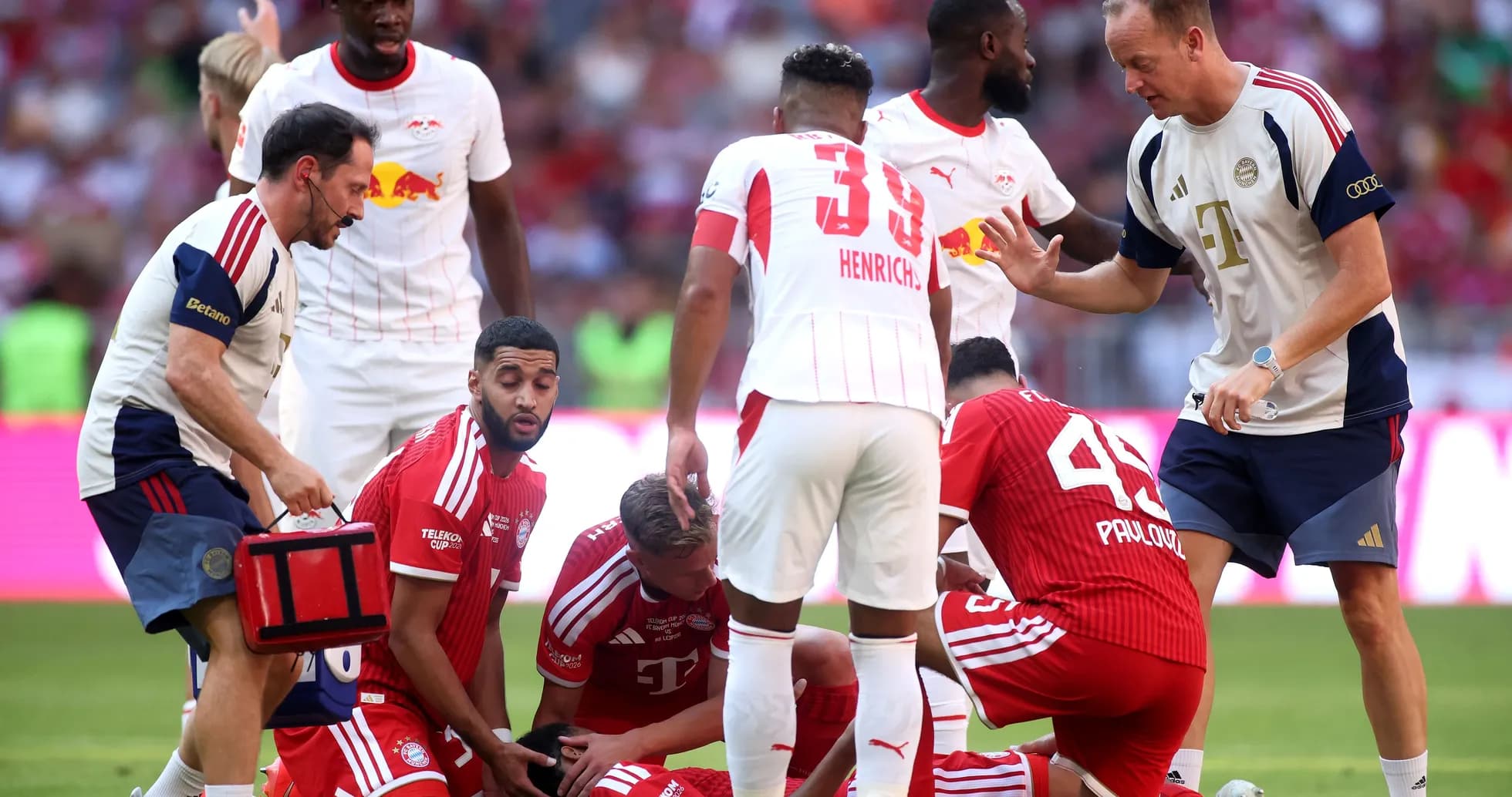 Jugadores de Bayern y Leipzig rodeando a un jugador caído
