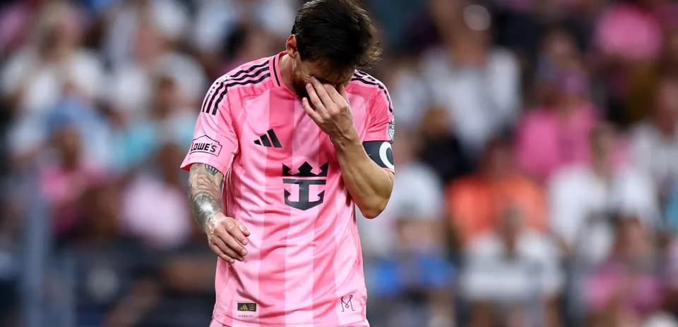 Jugador con camiseta rosa caminando por el campo