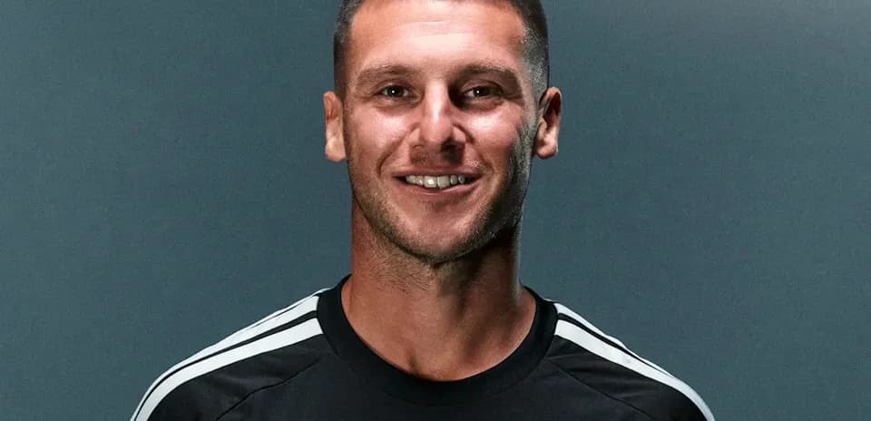 Jugador sonriendo en uniforme de fútbol negro