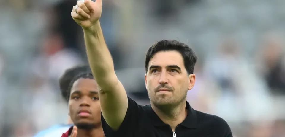 Entrenador saludando con pulgar hacia arriba en el campo