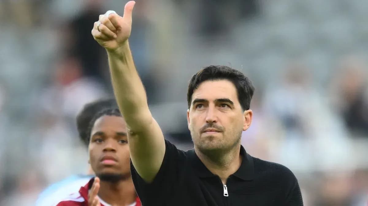 Entrenador saludando con pulgar hacia arriba en el campo